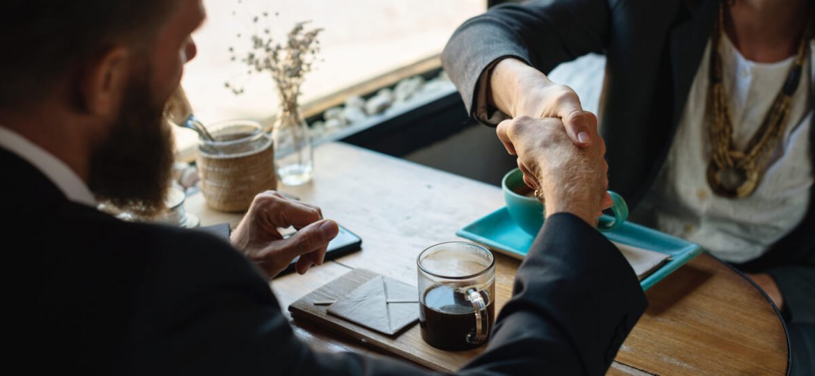 man and woman shaking hands over business dinner